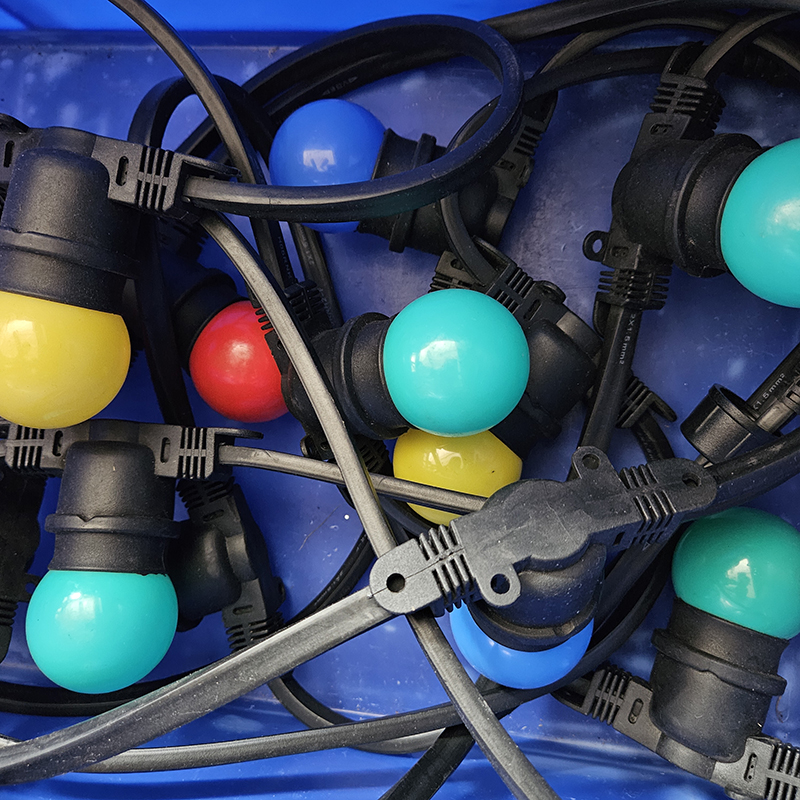 Eight shirts arranged on table in black, olive, grey, blue, white, red, mustard, and green.
