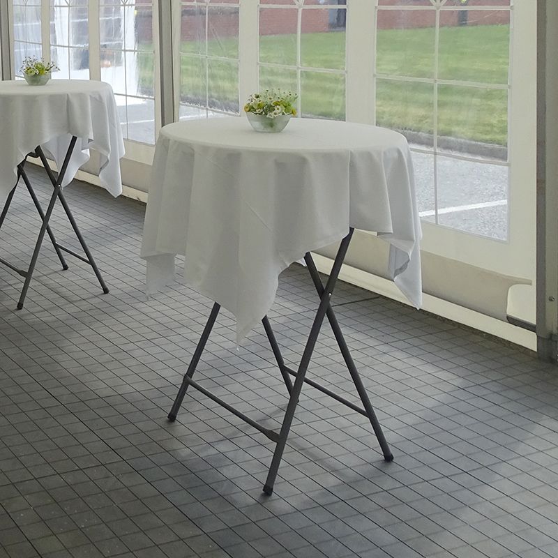 Eight shirts arranged on table in black, olive, grey, blue, white, red, mustard, and green.